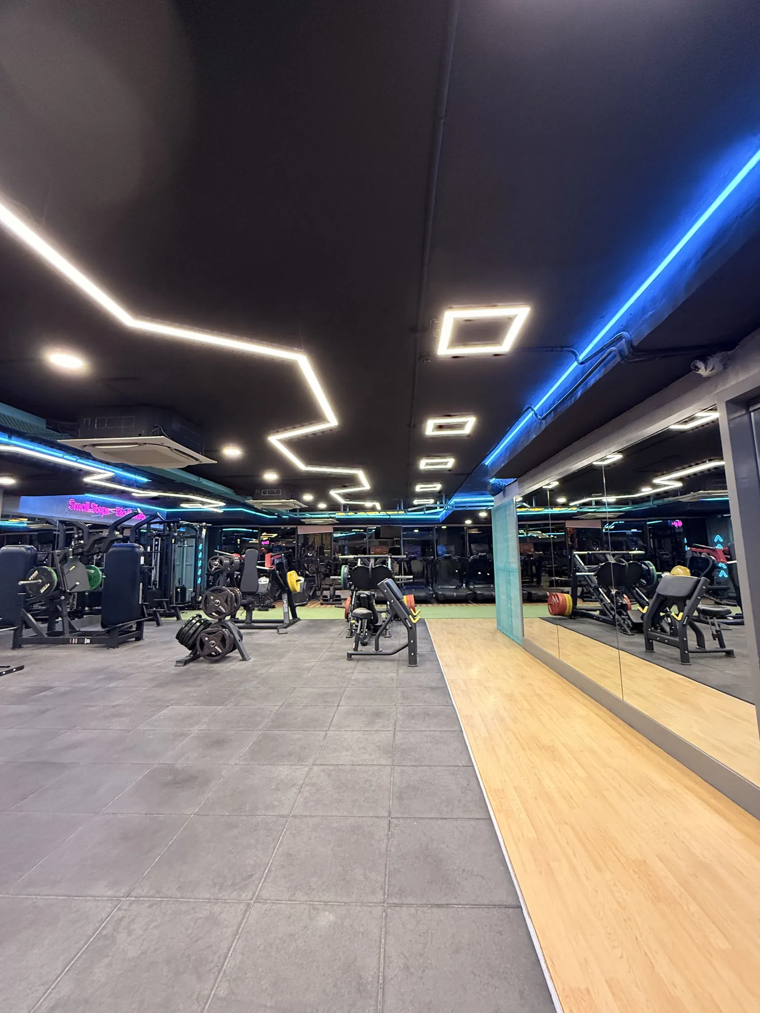 The length of the Fisique floor: tiled lifting area, wooden lane and mirrored wall under strip lighting